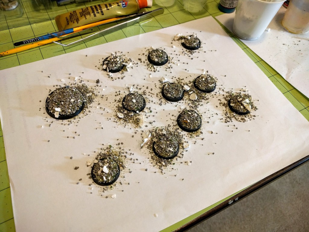 Bases being textured. Nearly all the gravel piled on will shake off and be scooped back into a cup to be used again later (use a clean sheet of scrap paper under them to help with this).