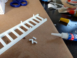 Gluing pegs to the rails.