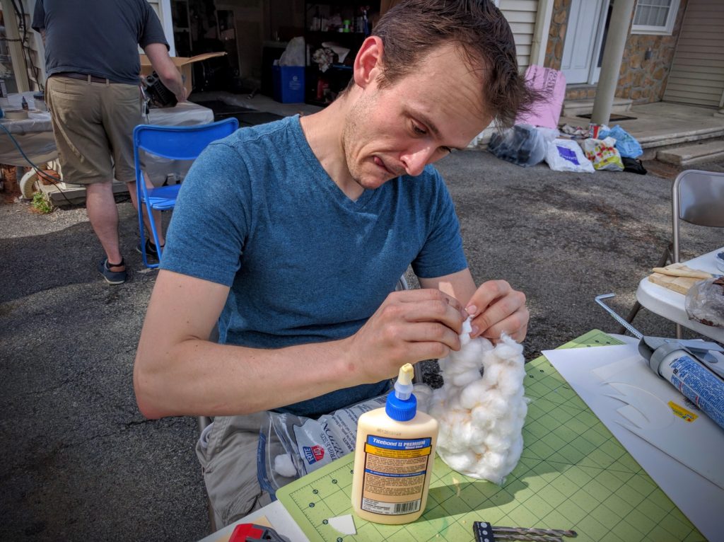 Alex gluing cotton balls into rough positions to start the smoke column.